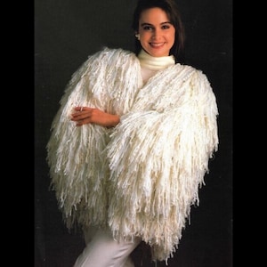 May include: A white shaggy cardigan with long sleeves and a loose fit. The cardigan is made of a soft, fluffy yarn and has a relaxed, casual style.