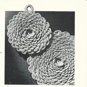 May include: Two crocheted pot holders in a circular shape with a raised, textured design. The pot holders are gray and have a loop at the top for hanging.