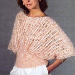 May include: A light pink knitted sweater with a loose, flowing fit and a slightly gathered waist.