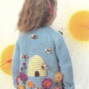 Puede incluir: Un c&aacute;rdigan de punto azul claro con una colmena y abejas bordadas en la espalda. La colmena es amarilla y tiene una peque&ntilde;a puerta marr&oacute;n. Tambi&eacute;n hay varias flores rosas, naranjas y amarillas bordadas en la espalda.