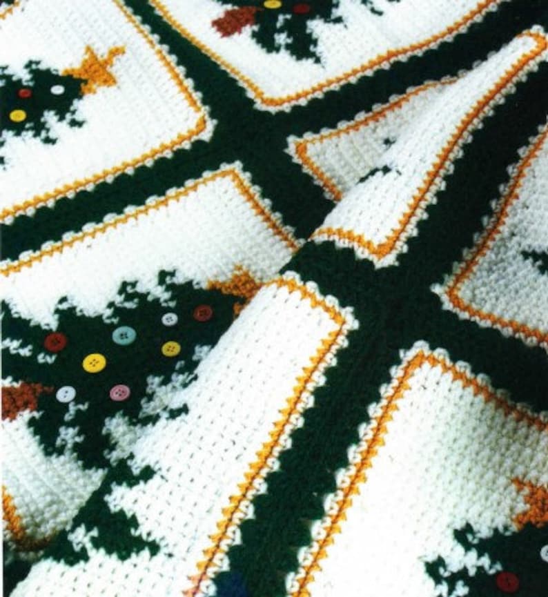 May include: A white crocheted blanket with a green and orange pattern of Christmas trees. The blanket is made with a variety of stitches and textures.