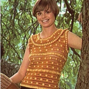 May include: A crocheted sleeveless top with a yellow and orange pattern. The top has a round neckline and a textured design.