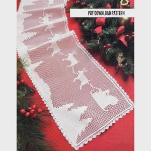 May include: White crocheted Christmas table runner with Santa Claus in a sleigh pulled by reindeer, and Christmas trees. The runner has a scalloped edge and is displayed on a red surface. The text "PDF DOWNLOAD PATTERN" is in the upper right corner.