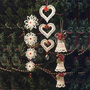 May include: A Christmas tree decorated with crocheted ornaments. The ornaments are in the shape of hearts, snowflakes, and bells. The ornaments are white with red accents.