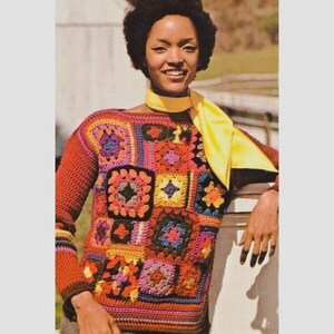 May include: A vintage-style crochet sweater featuring a patchwork design with various colorful squares. The sweater has long sleeves and a round neckline. The color palette includes shades of orange, red, blue, and yellow. A yellow scarf is draped around the neck.