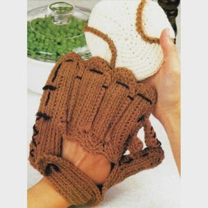 Peut inclure: Un gant de baseball crocheté marron et une balle de baseball crochetée blanche et marron. Le gant a des détails de couture noirs. La balle de baseball a des détails de couture marron. Les articles sont faits à la main et probablement pour la cuisine.