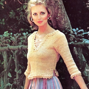 May include: A woman wearing a crocheted cream-coloured top with a V-neck and a crocheted trim. The top has a side slit and is worn with a striped skirt.