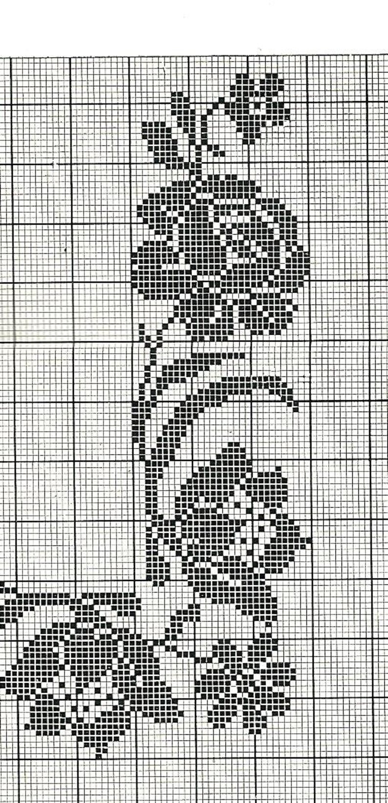 May include: Black and white cross stitch pattern featuring a floral design with leaves and flowers.