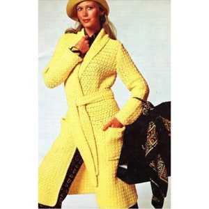 May include: A long yellow crocheted coat with a shawl collar, a belt, and pockets. The coat is worn by a model with blonde hair and a yellow hat.