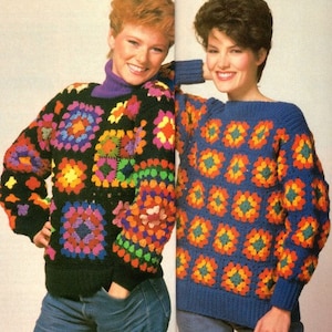 Könnte beinhalten: Zwei Frauen tragen bunte gehäkelte Pullover. Der Pullover links ist schwarz mit mehrfarbigen Quadraten. Der Pullover rechts ist blau mit orangefarbenen, grünen und gelben Quadraten.