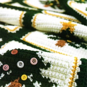 May include: A green and white crocheted blanket with a repeating pattern of squares and buttons. The blanket is made with a soft, textured yarn and has a vintage look.