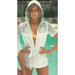 May include: White crochet hooded cover-up with a tie belt. The cover-up has a loose fit and a deep V-neckline.