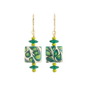 May include: A pair of dangle earrings with gold-colored hooks. Each earring features a white, square bead with a green and black swirl pattern. Green and yellow beads accent the square bead.
