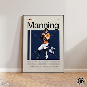 May include: A framed poster featuring a football player in an orange and blue uniform, holding a football. The poster has the name "Manning" in large black letters, a signature, and a series of numbers and text at the bottom. The background is a light beige color.