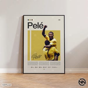 Könnte beinhalten: Ein gerahmtes Poster mit Pelé, einem berühmten Fußballspieler, in einem gelb-schwarzen Farbschema. Das Poster enthält den Namen "Pelé" in Großbuchstaben, eine Unterschrift und ein Foto von Pelé, der ein Tor feiert. Das Poster wird auf einem Holzboden ausgestellt.