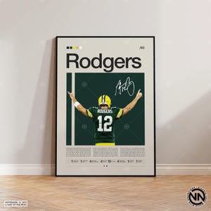 May include: Framed poster with a football player in a green and yellow uniform, number 12. The poster features the name "Rodgers", a signature, and a colour block design. The background is a light beige.