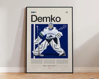 Puede incluir: Un póster enmarcado con un portero de hockey sobre hielo con uniforme blanco y azul, con el nombre "Demko" en letras grandes. El póster tiene un fondo azul e incluye el texto "Vancouver" y el número "95".
