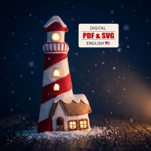Könnte beinhalten: Ein Leuchtturm aus Filz mit roten und weißen diagonalen Streifen, beleuchteten Fenstern und einem kleinen angebauten Haus, das mit Schnee bedeckt ist. Ein rechteckiges Schild zeigt den Text DIGITAL PDF & SVG ENGLISH mit einer US-Flagge.