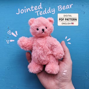 Może przedstawiać: Mały, puszysty, różowy pluszowy miś z czarnymi oczami i czarnym nosem. Napis Jointed Teddy Bear w kolorze jasnoróżowym znajduje się nad misiem, a biała ramka zawiera tekst DIGITAL PDF PATTERN ENGLISH z małą ikoną flagi amerykańskiej.