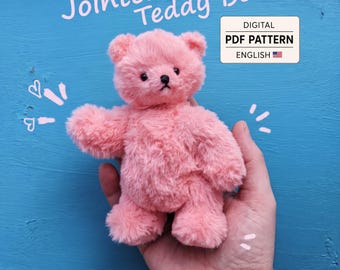 May include: A small, fuzzy, pink teddy bear with black eyes and a black nose. The text Jointed Teddy Bear is written in light pink above the bear, and a white box contains the text DIGITAL PDF PATTERN ENGLISH with a small American flag icon.