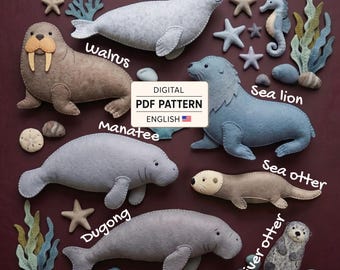 May include: A digital PDF pattern in English featuring felt marine animal shapes including a walrus, seal, sea lion, manatee, dugong, sea otter, and river otter, accompanied by felt starfish, seaweed, and stones, all labeled with their names.
