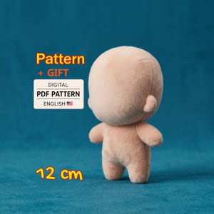 May include: A light peach-colored plush doll with a rounded head and small ears. Text on the image reads: Pattern + GIFT DIGITAL PDF PATTERN ENGLISH and 12 cm. The doll has a smooth, soft texture and a simple, featureless face design.