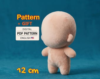 May include: A light peach-colored plush doll with a rounded head and small ears. Text on the image reads: Pattern + GIFT DIGITAL PDF PATTERN ENGLISH and 12 cm. The doll has a smooth, soft texture and a simple, featureless face design.