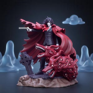 May include: A detailed figurine of a dark-haired character in a black suit and flowing red cape, holding a silver handgun. Beside the figure are two red, multi-eyed wolf-like creatures, a stone cross, and skulls on a textured, rocky base.