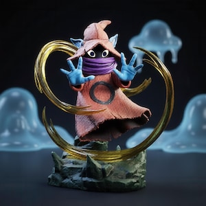 May include: A figurine of a hooded character with a textured terracotta-colored robe, a purple neck wrap, and blue hands. The figure stands on a dark green rocky base, surrounded by a translucent golden circular energy effect and light blue blobs.