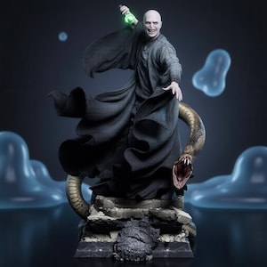 May include: A detailed figurine of a bald, pale character in a long, flowing black robe, holding a glowing green wand aloft. A large, brown, scaled snake with an open mouth coils around the base, which features stone-like rubble and a crest.