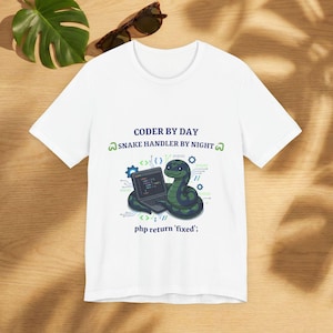May include: White t-shirt with the text "CODER BY DAY SNAKE HANDLER BY NIGHT". The graphic features a green snake with a laptop and the text "php return 'fixed'". The design includes binary code and gear icons.