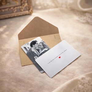 May include: A brown envelope containing a black and white photo card of a kissing couple. A white card with the text "From This Day Forward, You are My Always" and a red heart is also visible.