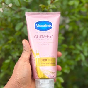 Pode incluir: Um tubo rosa de lo&ccedil;&atilde;o Vaseline Gluta-Hya Serum Burst com tampa branca. O tubo tem detalhes em azul e dourado e cont&eacute;m 290 ml. O texto no tubo diz "Healthy Bright" e "Dewy Radiance".