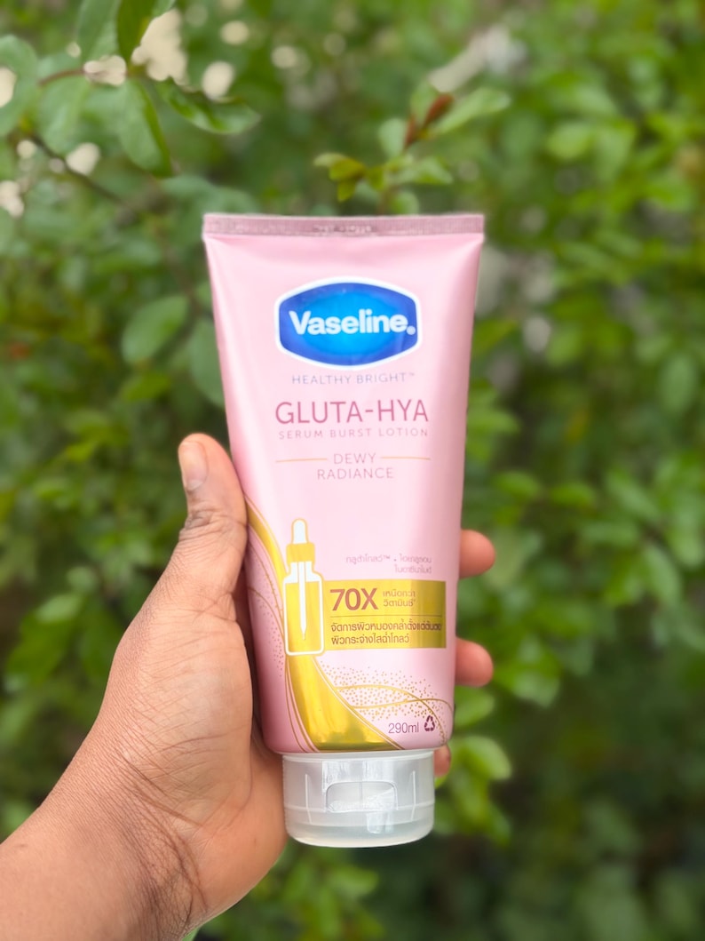 Pode incluir: Um tubo rosa de lo&ccedil;&atilde;o Vaseline Gluta-Hya Serum Burst com tampa branca. O tubo tem detalhes em azul e dourado e cont&eacute;m 290 ml. O texto no tubo diz "Healthy Bright" e "Dewy Radiance".