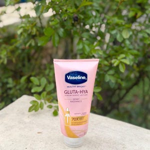 Pode incluir: Um tubo rosa de lo&ccedil;&atilde;o Vaseline Gluta-Hya Serum Burst com tampa branca. O tubo tem detalhes azuis e dourados e as palavras "Healthy Bright" e "Dewy Radiance" s&atilde;o vis&iacute;veis. A lo&ccedil;&atilde;o tem 250 ml.