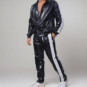 Puede incluir: Un chándal negro con un acabado brillante y húmedo. La chaqueta tiene cremallera frontal y rayas blancas en las mangas. Los pantalones a juego también tienen rayas blancas en los laterales. El conjunto se completa con zapatillas blancas.