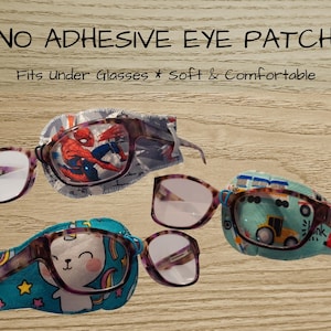 Può includere: Quattro paia di occhiali con toppe decorative per gli occhi. Le toppe presentano disegni colorati, tra cui una grafica di Spiderman, un unicorno e un motivo di veicoli da costruzione. Il testo sull'immagine recita "NO ADHESIVE EYE PATCH" e "Fits under Glasses * soft & Comfortable."