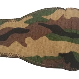 May include: Camouflage fabric eye patch with a black elastic strap and a black cord loop. The patch is sewn with brown thread.