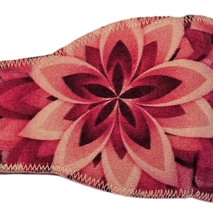 Pode incluir: Atadura para olho rosa com um padrão floral. A atadura tem uma faixa elástica e um fecho de correr.