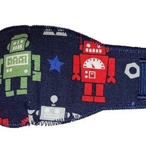 May include: A blue eye patch with a robot pattern. The patch features two robots, one green and one red, with a star and other robot details on a navy blue background.