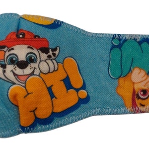 Può includere: Cerotto per l'occhio blu a tema Paw Patrol. Presenta un'immagine di cartone animato di Chase il cane con il testo "Ciao!" e un'immagine di cartone animato di Skye il cane con il testo "Paw Patrol".