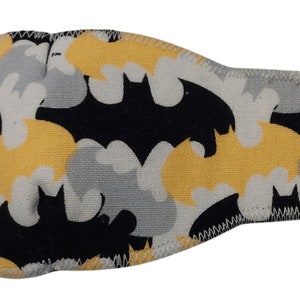 May include: Black eye patch with a yellow and gray bat pattern. The eye patch is made of soft fabric and has an elastic strap.
