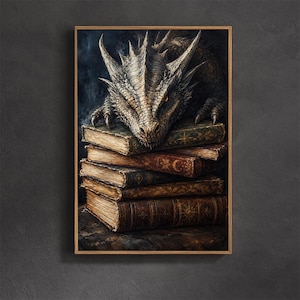 May include: A framed wall art print featuring a detailed illustration of a scaly, light-colored dragon with glowing orange eyes resting its head on a stack of five antique, leather-bound books with gold-embossed celestial symbols on the covers.