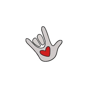 Puede incluir: Un parche bordado que muestra una mano de color gris claro haciendo el signo de te quiero en lengua de signos americana. La mano tiene un contorno negro y un corazón rojo sólido centrado en la palma, con una apariencia de tela texturizada.
