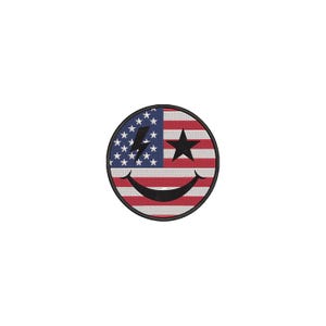 Può includere: Toppa circolare con un disegno ispirato alla bandiera americana. Presenta stelle, strisce, una stella nera e un fulmine. Una faccina sorridente nera nella parte inferiore, con un bordo nero.
