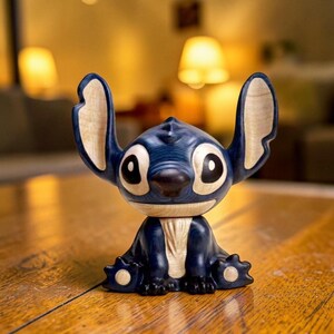 May include: A blue wooden figurine of a cartoon character with large ears, big eyes, and a dark nose. The figurine is sitting on a wooden surface. The ears and chest have a light wood grain appearance.