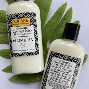 May include: Two white body lotion bottles with black caps and labels. The labels read "KOHANA" and "Organic Coconut Milk Body Lotion" with "Plumeria" below. The other bottle reads "Intensive Moisturizing Body Lotion". The bottles are 4 ounces.