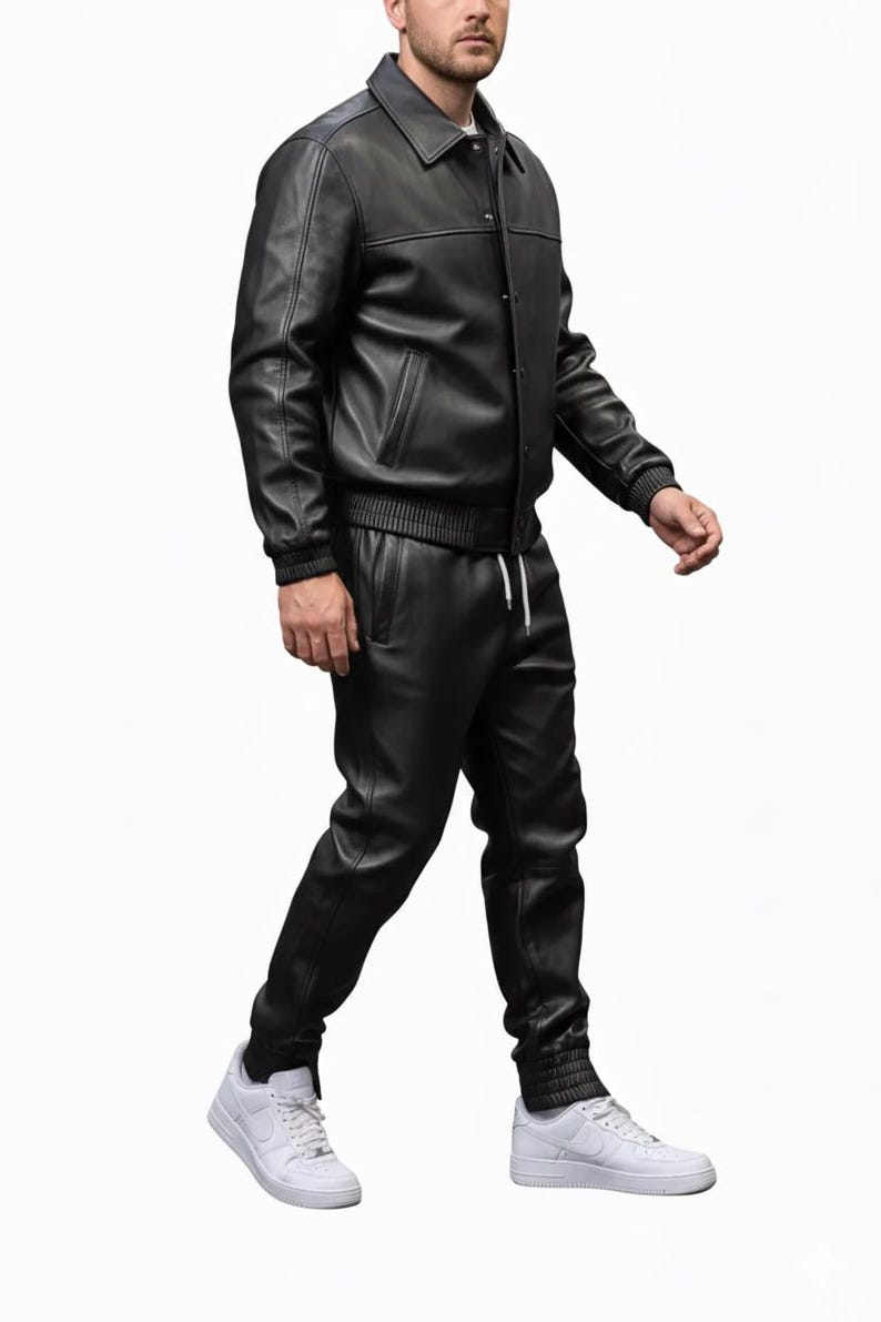 May include: A black leather jacket with a collared neckline and button closure, paired with matching black leather pants. The pants have a drawstring waist. The outfit is completed with white sneakers.