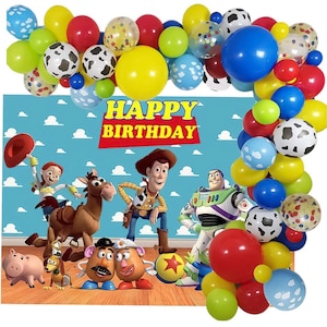 Peut inclure: Une sc&egrave;ne de f&ecirc;te d'anniversaire color&eacute;e avec des ballons et des personnages du film Toy Story. La toile de fond affiche "HAPPY BIRTHDAY" et des images de Woody, Buzz l'&Eacute;clair et d'autres personnages. Des ballons de diff&eacute;rentes couleurs entourent la sc&egrave;ne.
