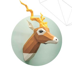 May include: A geometric papercraft antelope head with a light brown body, white accents, and yellow horns. The antelope is set against a light teal circle, with the text "ANTILOPE CERVICAPRA" below.
